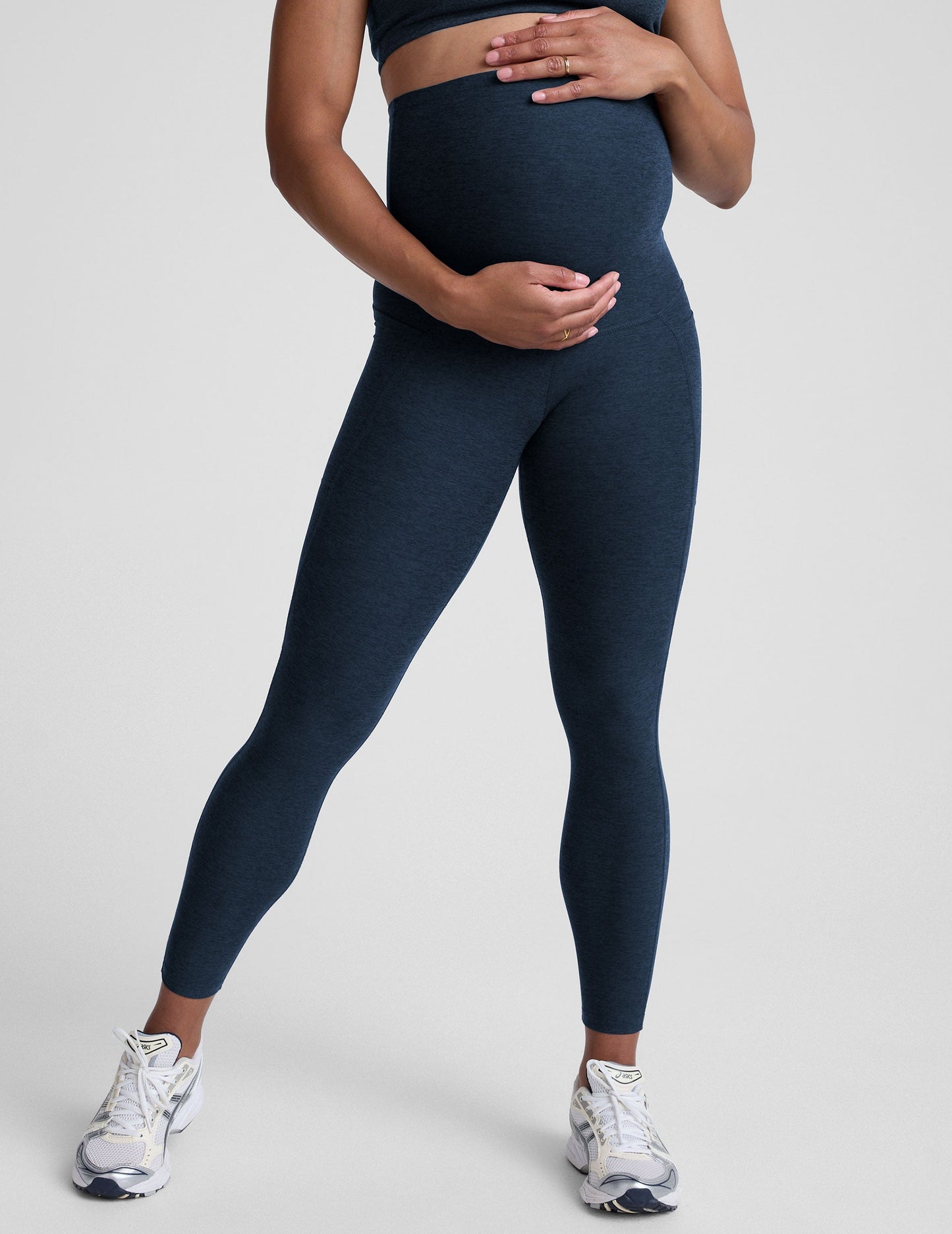 Person wearing navy leggings on a plain background.