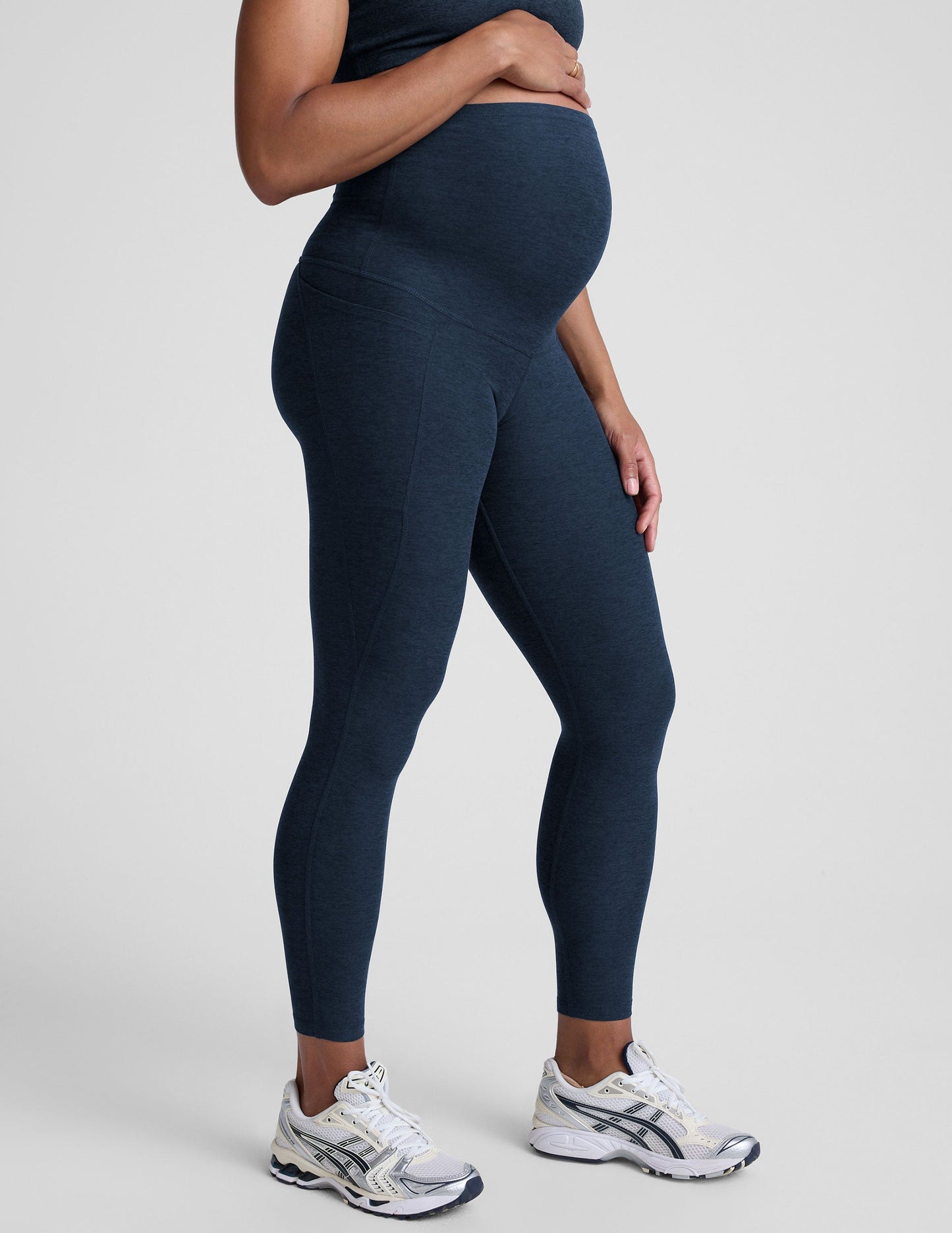 Person wearing navy leggings on a plain background.