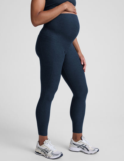 Person wearing navy leggings on a plain background.