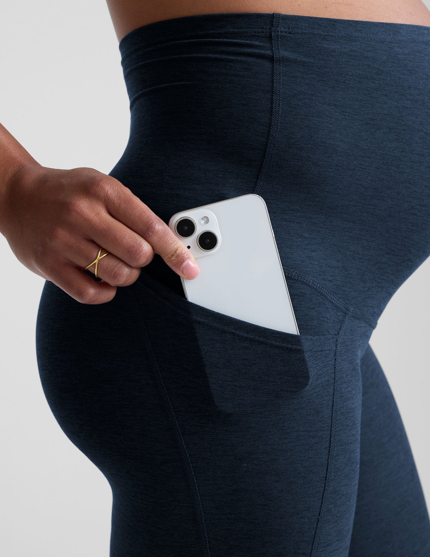 Person wearing navy leggings on a plain background.