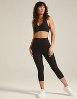 Model wearing Spacedye Out Of Pocket High Waisted Capri Legging in marled black, showing high waist and side pockets.