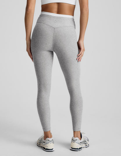 Person wearing gray leggings on a plain background.