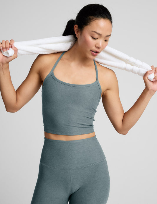 Woman wearing a gray athletic outfit on a white background.