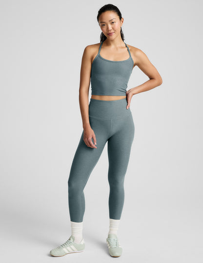 Woman wearing a gray athletic outfit on a white background.