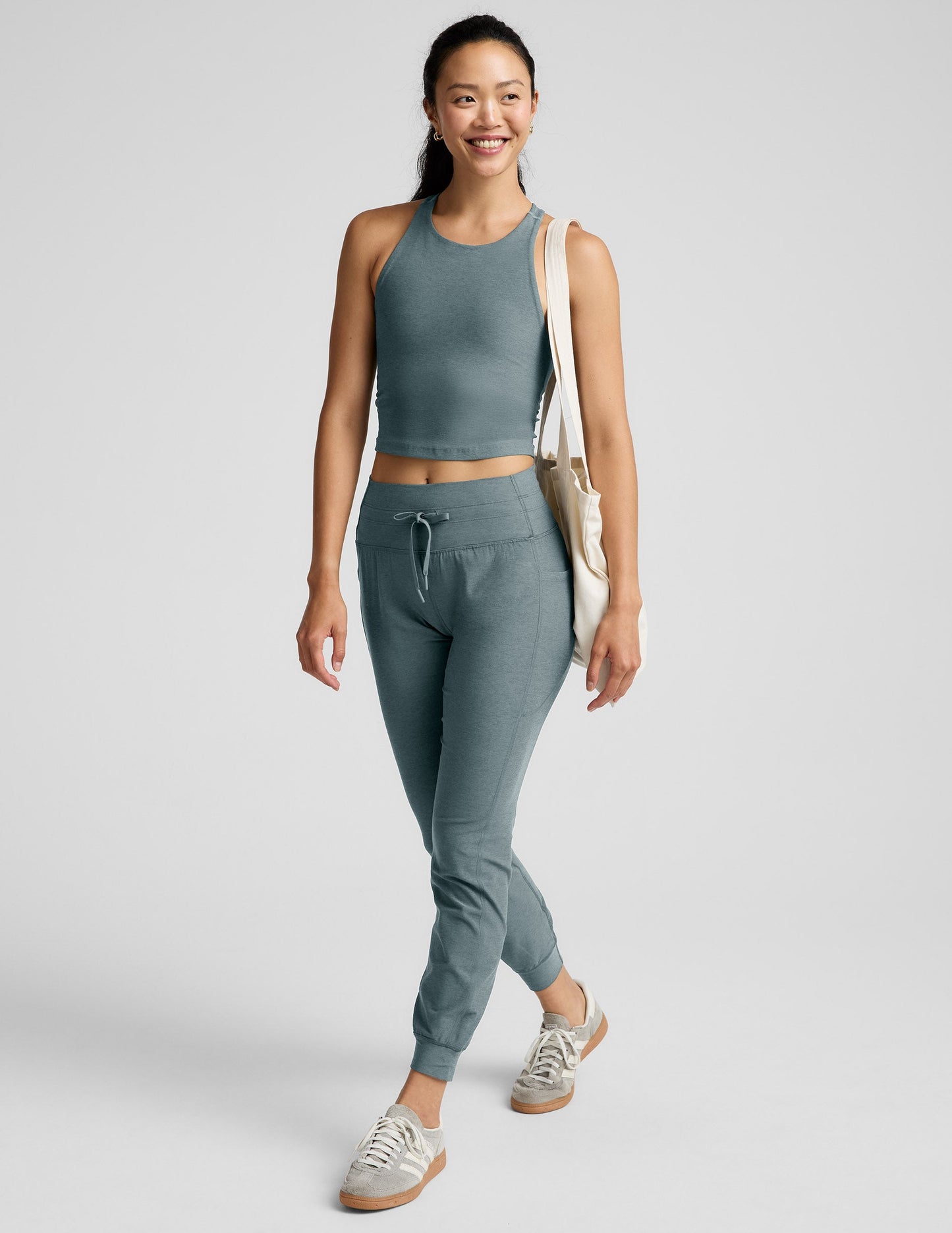Woman wearing a green athletic outfit on a light gray background.