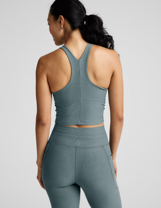 Woman wearing a green athletic outfit on a light gray background.