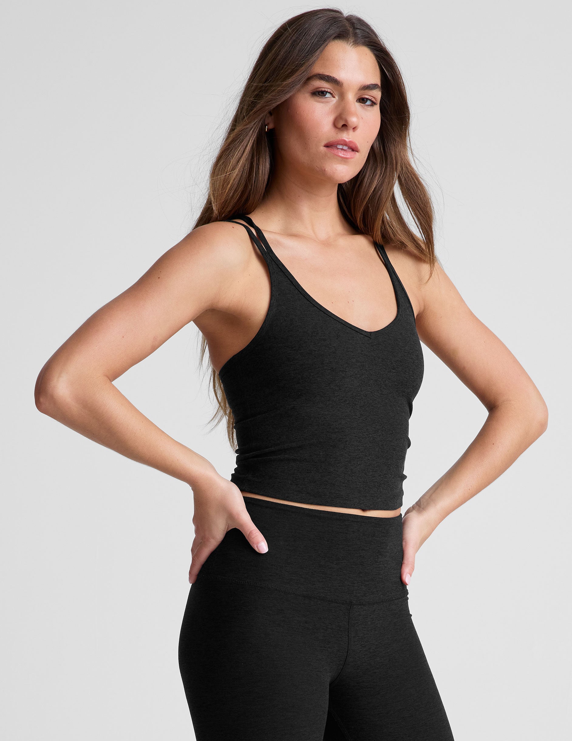 black waist length, V neckline​ tank top with a self shelf bra and criss-cross strap back detail​.