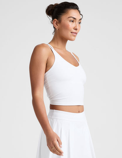 white waist length, V neckline​ tank top with a self shelf bra and criss-cross strap back detail​.