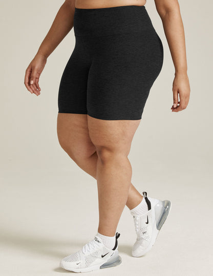 Model in black Spacedye High Waisted 7" Biker Shorts and white sneakers, shown from the waist down in a side-profile stance.