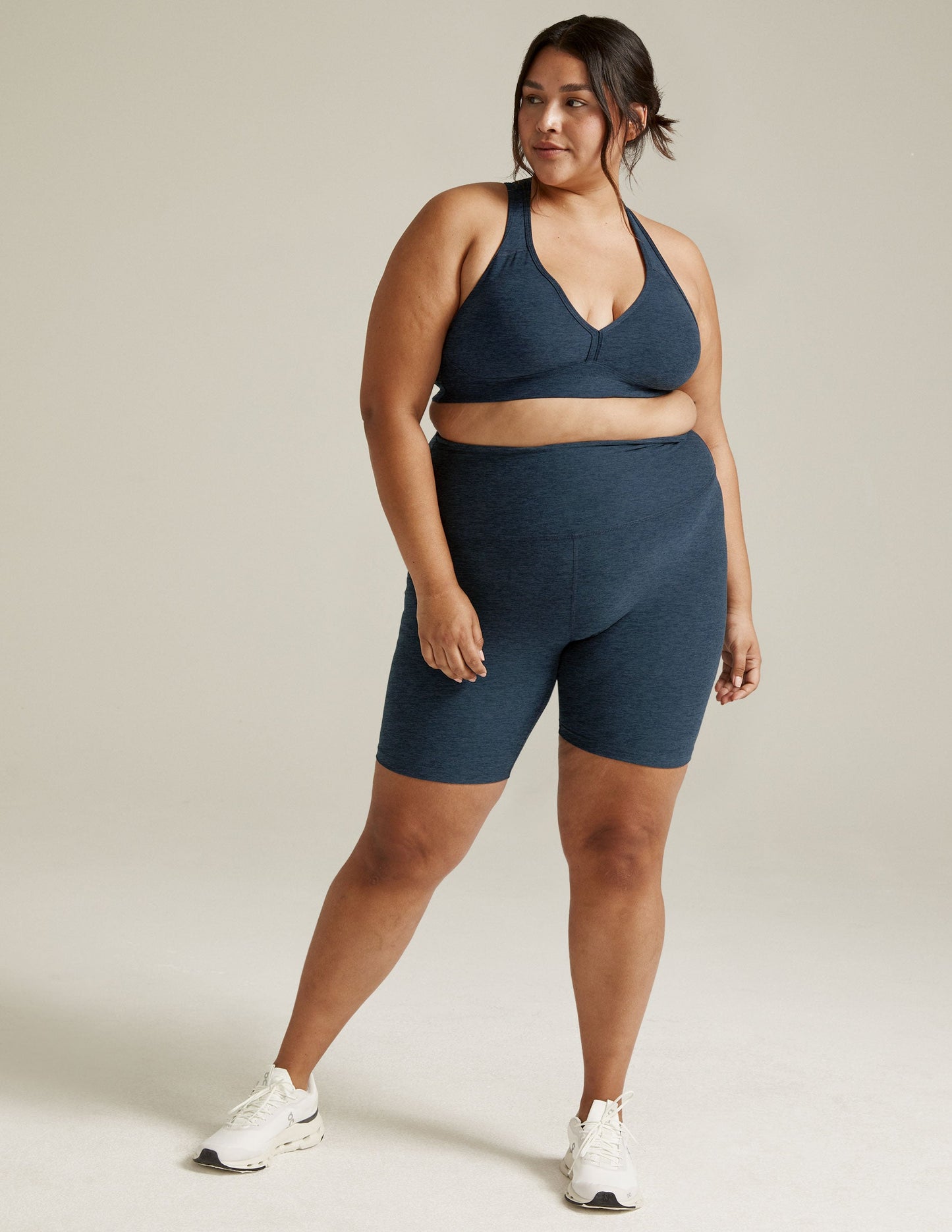 Woman wearing Spacedye High Waisted 7" Biker Short in Nocturnal Navy marled fabric with a matching sports bra.