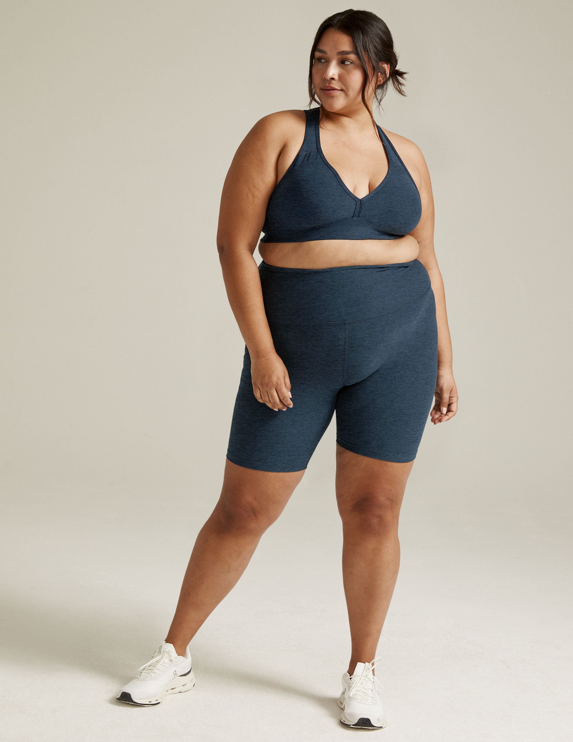 Woman wearing Spacedye High Waisted 7" Biker Short in Nocturnal Navy marled fabric with a matching sports bra.
