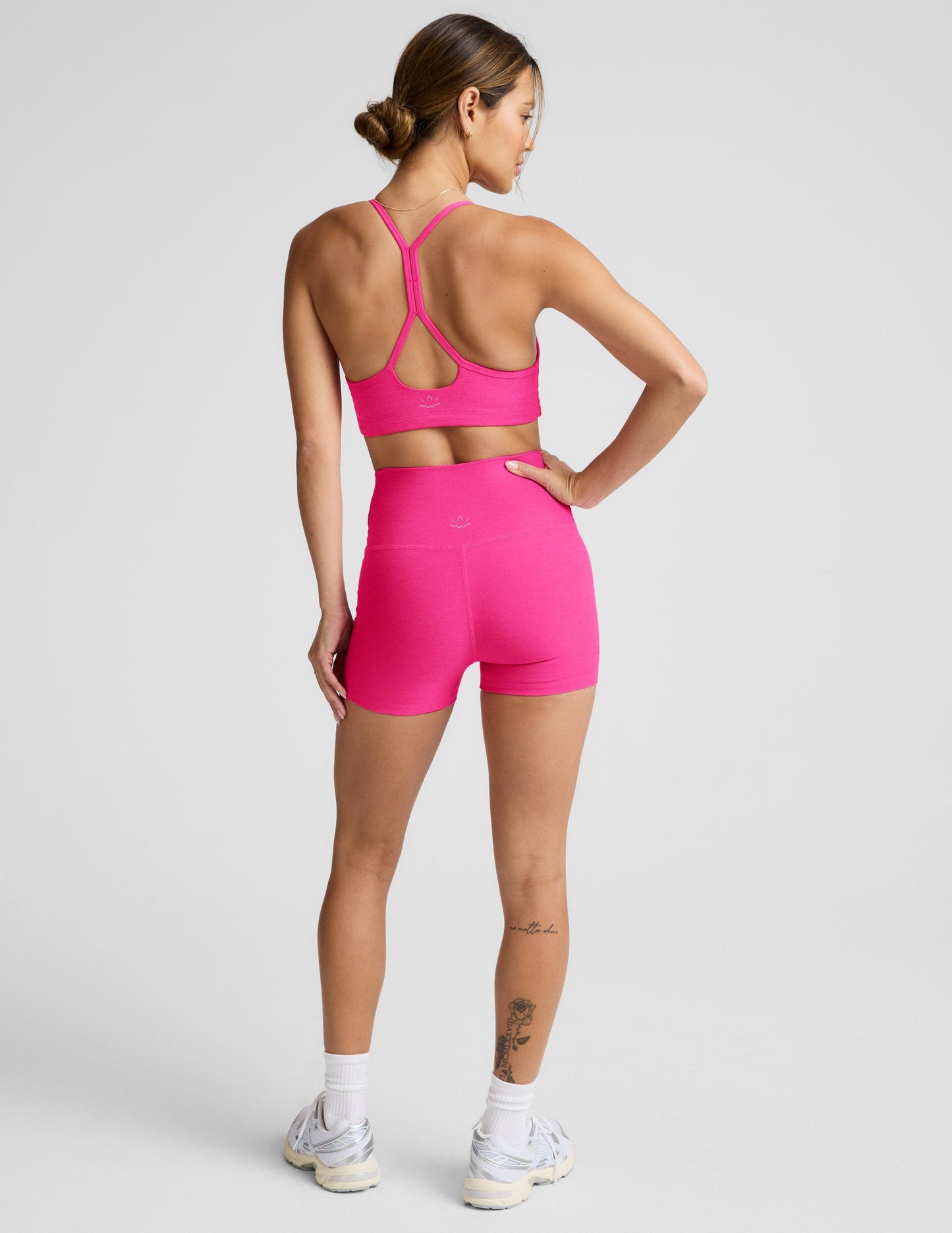 Back view of a woman wearing fuchsia Spacedye Keep Pace 3" Shorts with a high waistband and matching athletic sports bra.