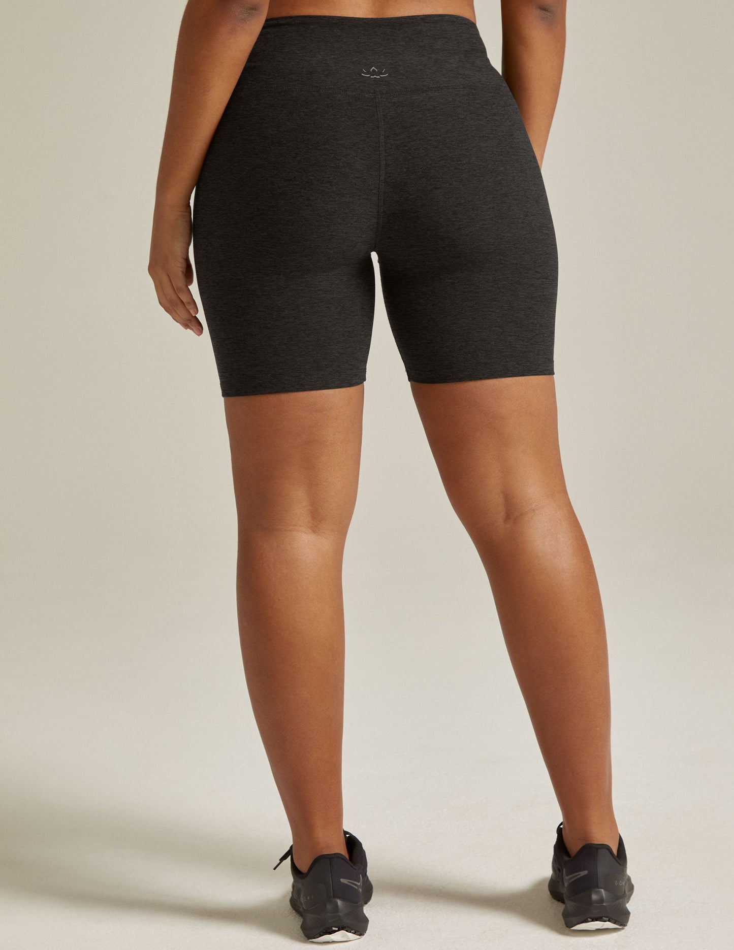 Woman wearing Gray Spacedye Keep Pace 5" Biker Short™ paired with black sneakers, rear view.