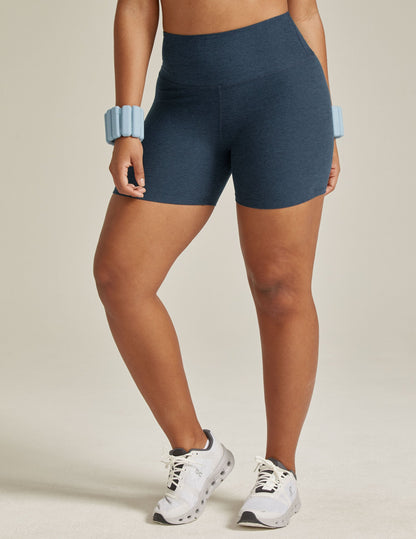 Front view of a model in marled navy Spacedye Keep Pace 5" Biker Short with a high waistband and snug, mid-thigh fit.