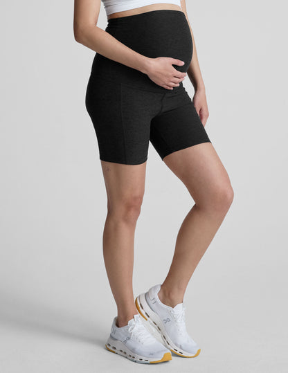 Spacedye Keep Pace 5" Maternity Pocket Biker Short in black on a pregnant model with a high-waist over-the-bump fit.