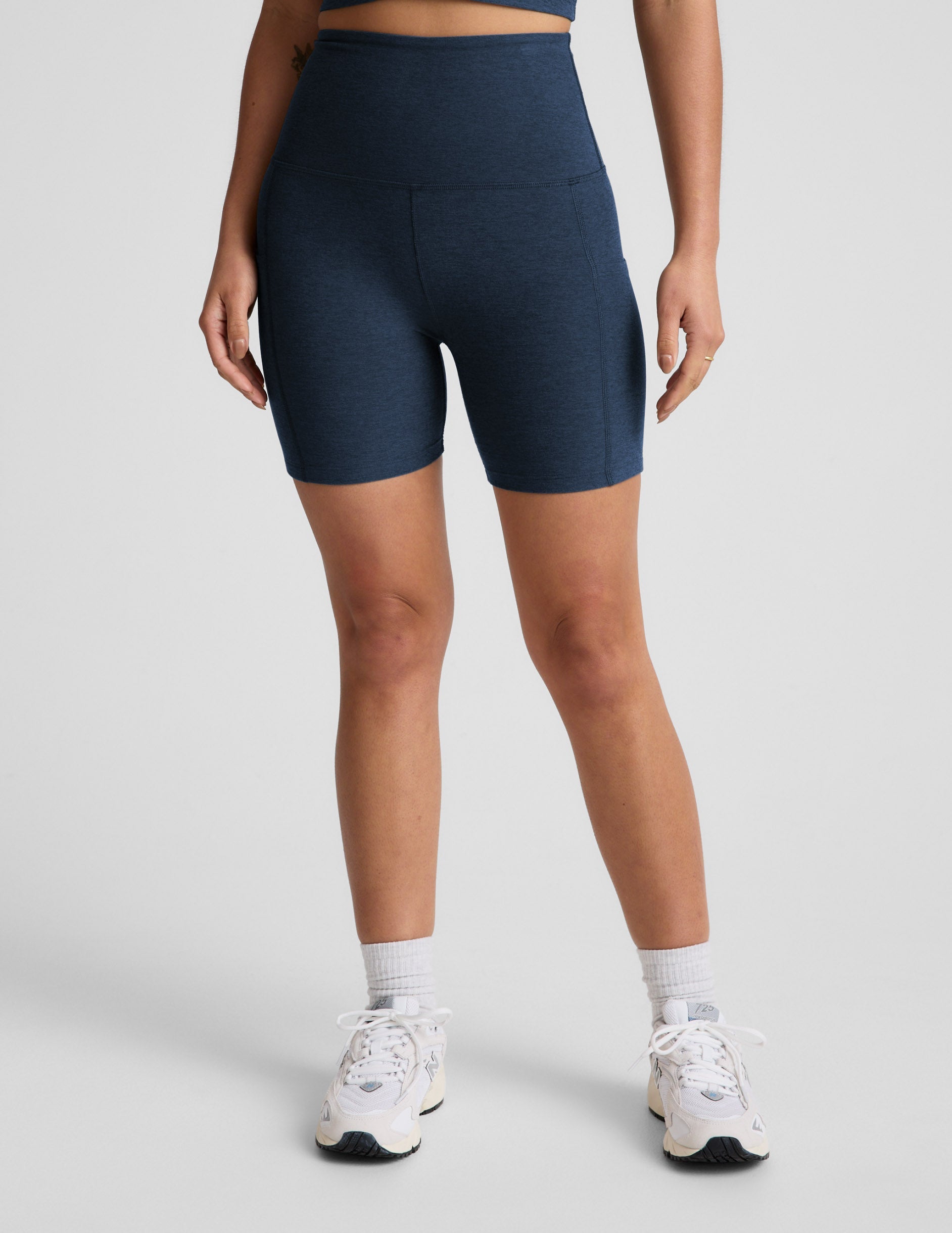 Person wearing navy blue athletic shorts on a light gray background.