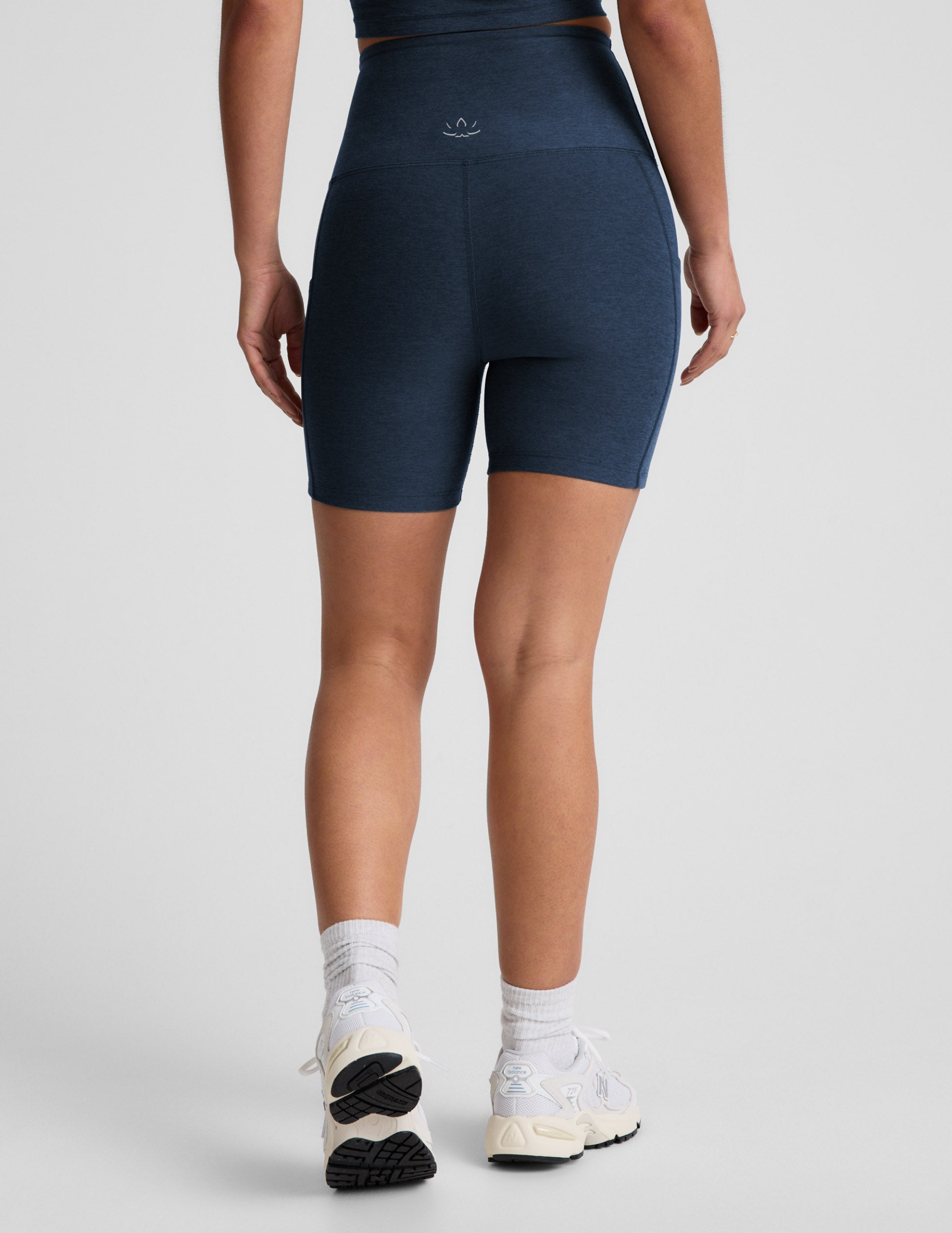 Person wearing navy blue athletic shorts on a plain background.