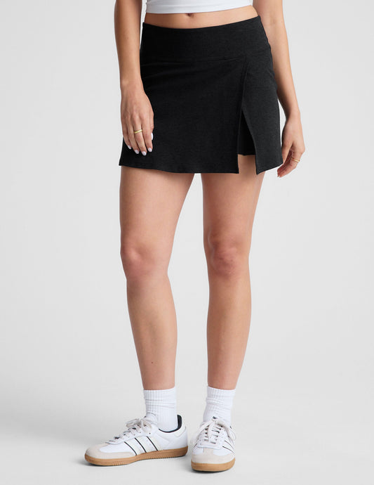 Spacedye Points Crossover Skirt in black, featuring a wide waistband, A-line fit, and overlap side slit with built-in shorts.