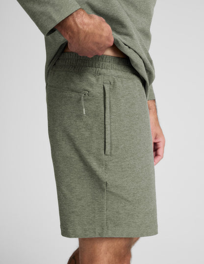 Man wearing Olive Spacedye Unlimited Men's Short™ with a matching top, side profile showing side zippered pocket.