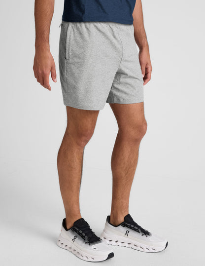 Gray marled Spacedye Unlimited Men's Short with elastic waistband and side zip pocket, hitting at mid-thigh on a model.