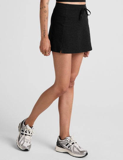 Black Spacedye Go Pocket Skirt on model, featuring a high drawstring waistband, A-line mini fit, and side slit at the hem.