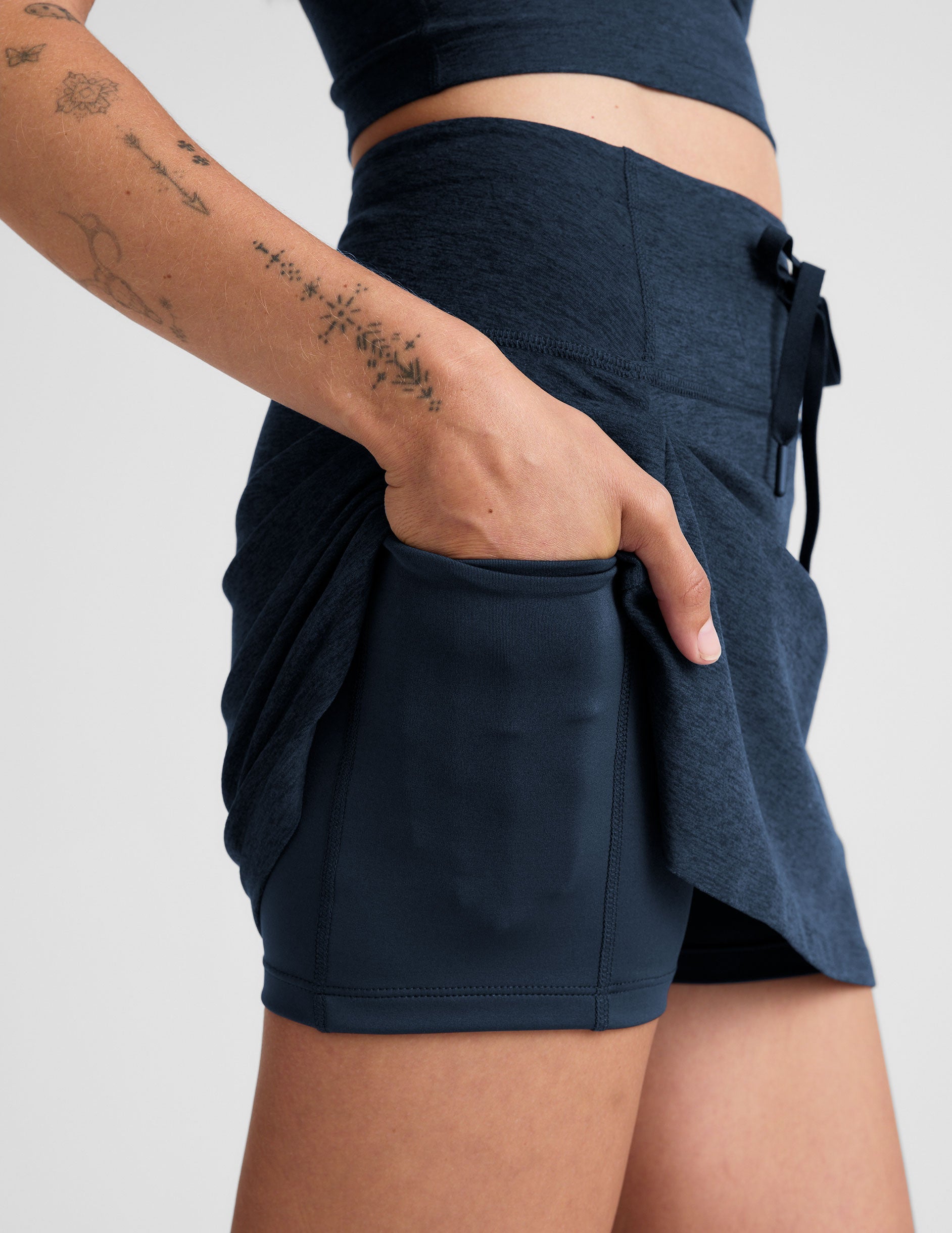 Side view of Navy Spacedye Go Pocket Skirt showing the drawstring waist and a hand in the built-in liner's side pocket.