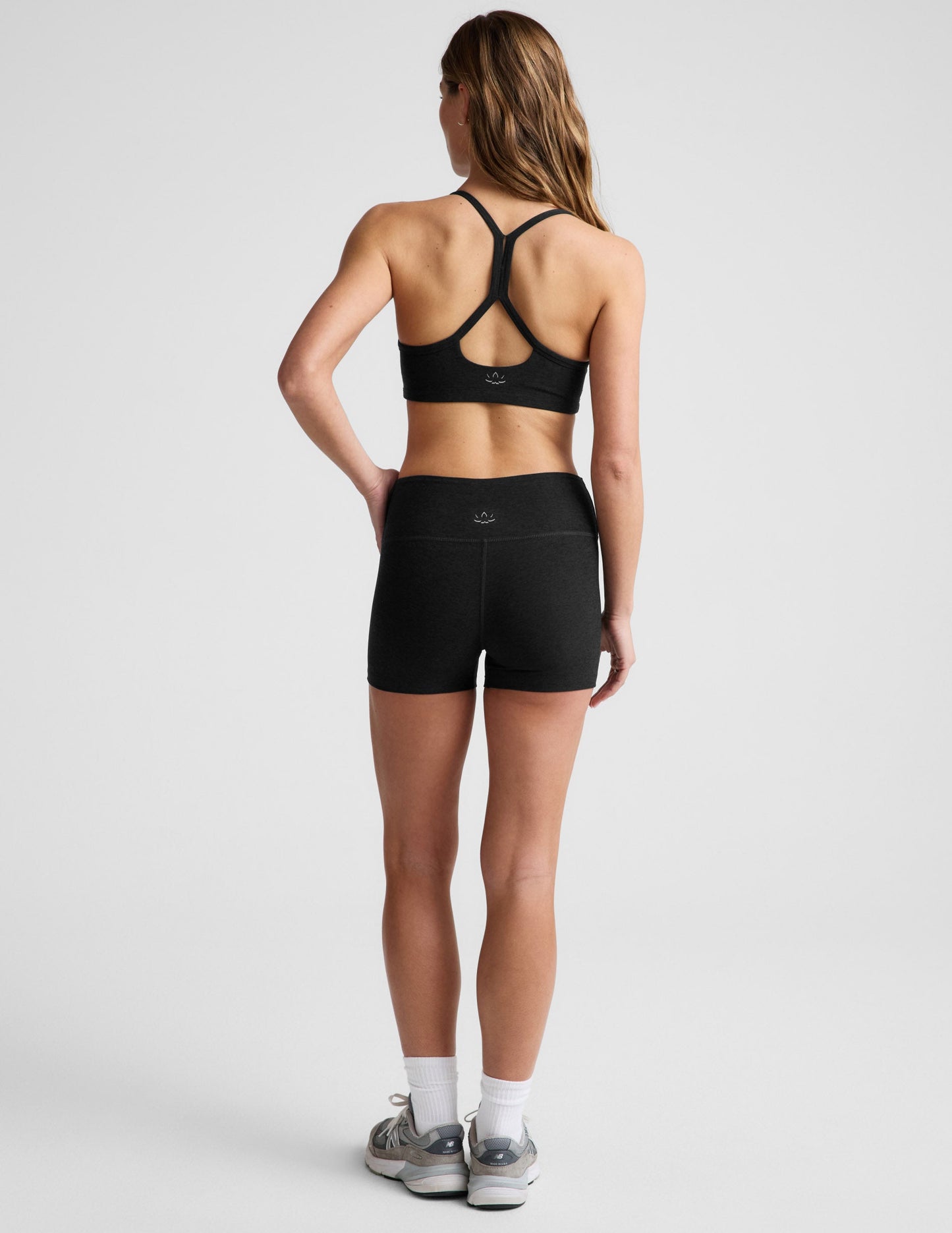 Rear view of a model in black Spacedye Keep Pace 3" Mid-Rise Shorts showing the snug fit, mid-rise waist, and short length.