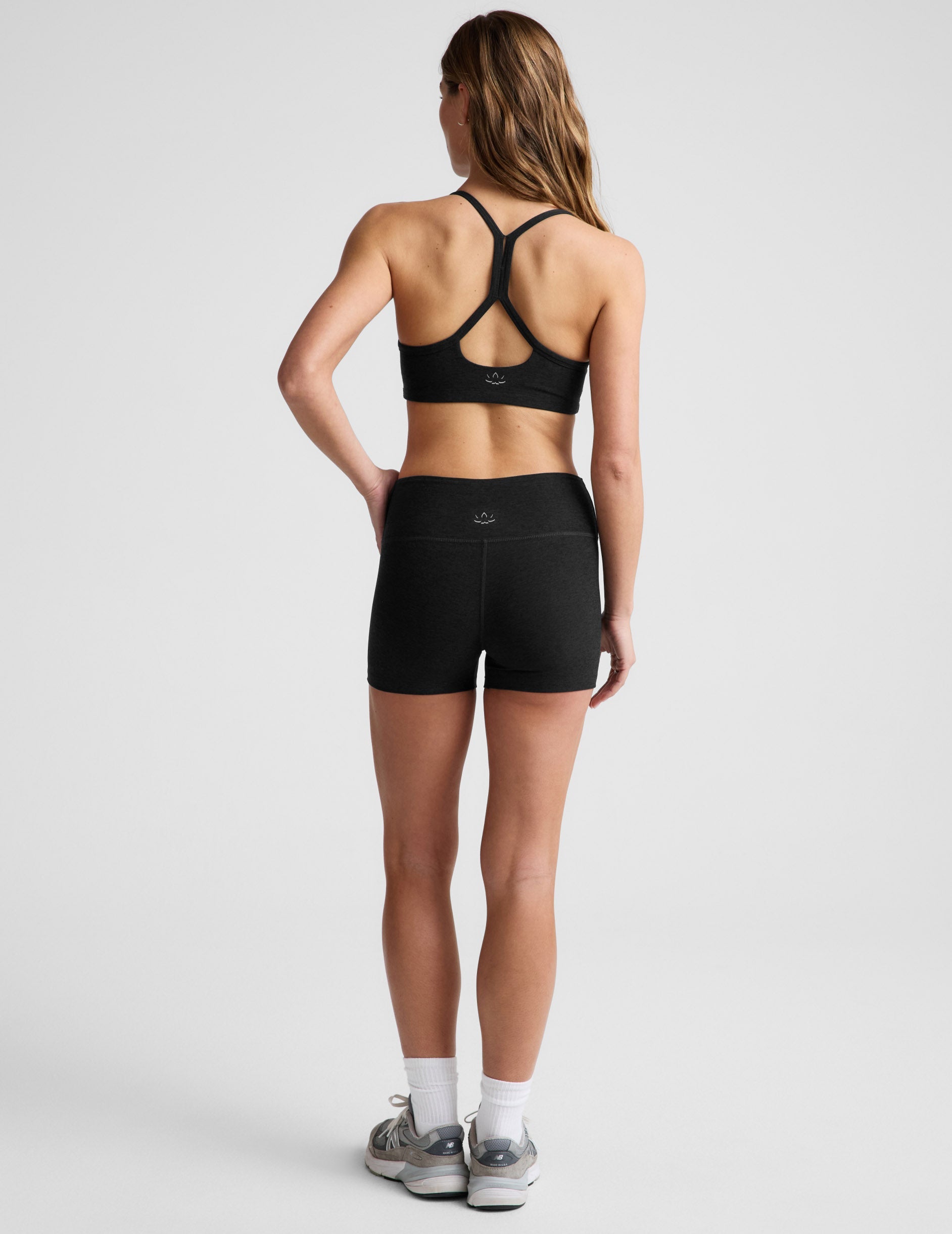 Rear view of a model in black Spacedye Keep Pace 3" Mid-Rise Shorts showing the snug fit, mid-rise waist, and short length.