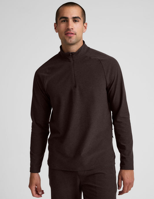model wearing a brown men's quarter-zip pullover against a plain background.