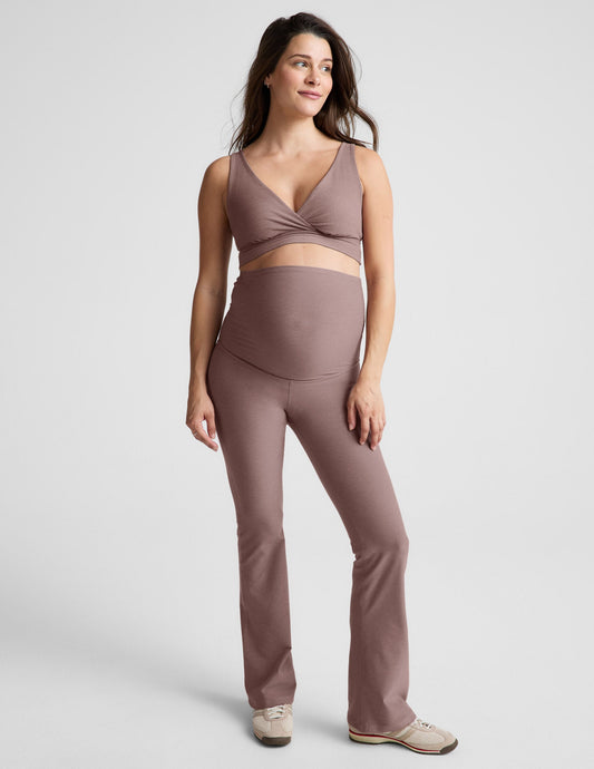 Woman wearing a brown maternity bra and pants against a plain background.
