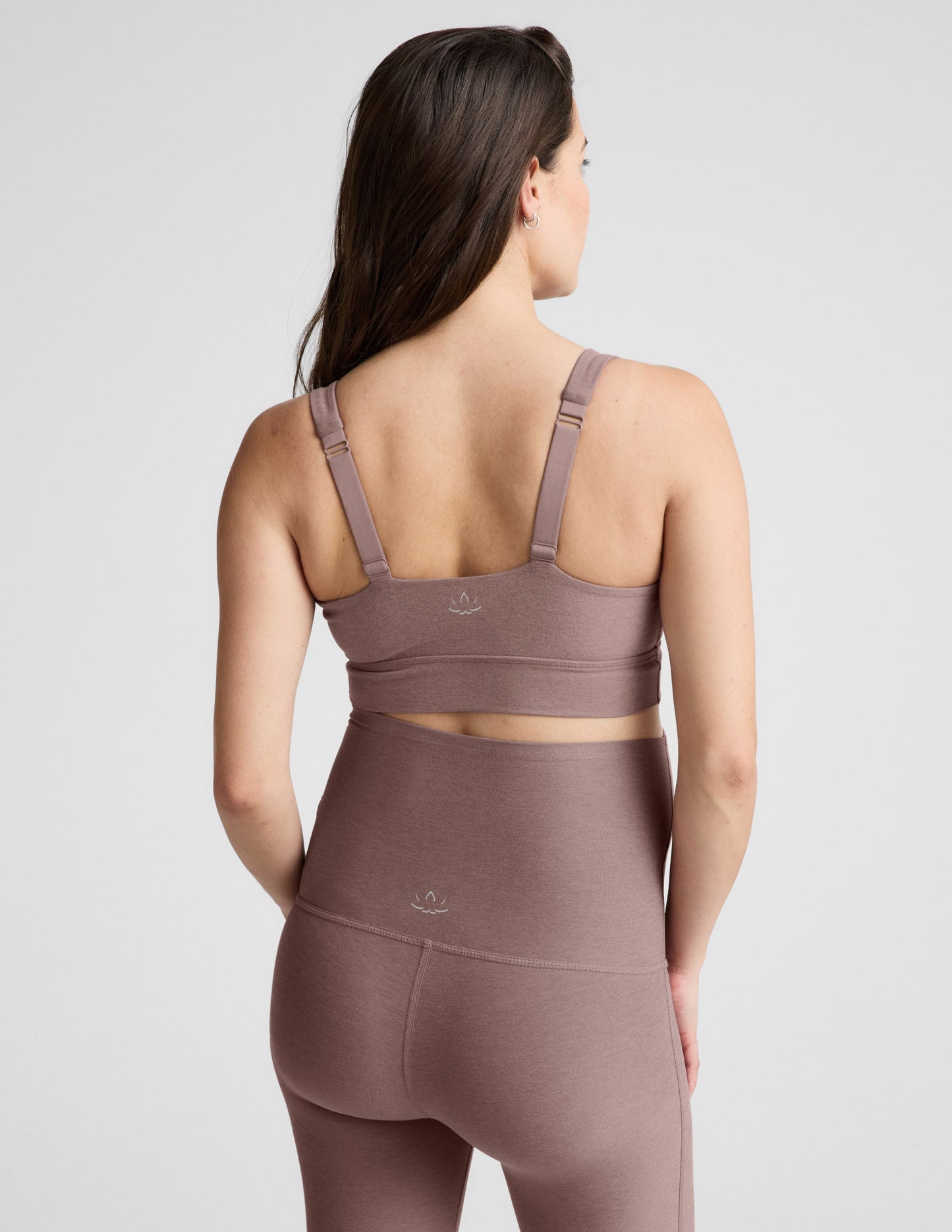 Woman wearing a brown maternity bra and pants against a plain background.