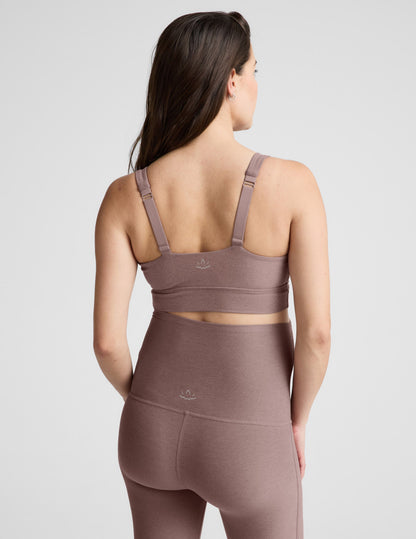 Woman wearing a brown maternity bra and pants against a plain background.