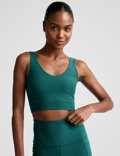 Woman wearing a green athletic outfit on a plain background.