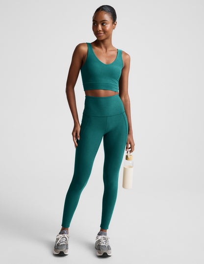 Woman wearing a green athletic outfit on a plain background.