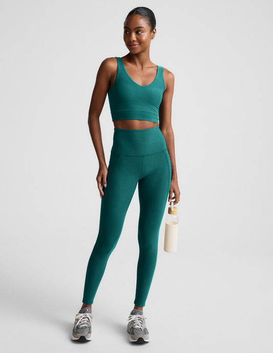 Woman wearing a green athletic outfit on a plain background.