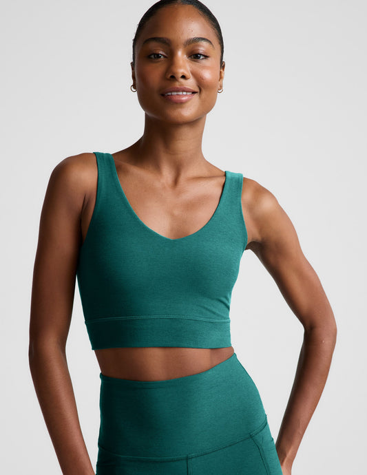 Woman wearing a green athletic outfit on a plain background.