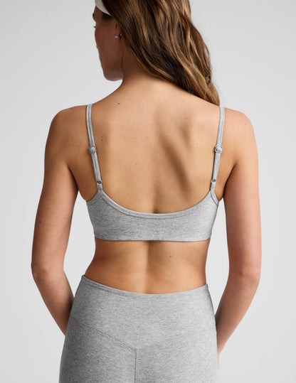 Woman wearing gray bra and pedal pushers against a plain background.