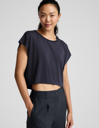 Woman wearing a blue shorts and trousers on a plain background.