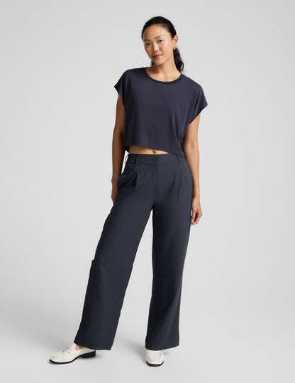 Woman wearing a blue shorts and trousers on a plain background.