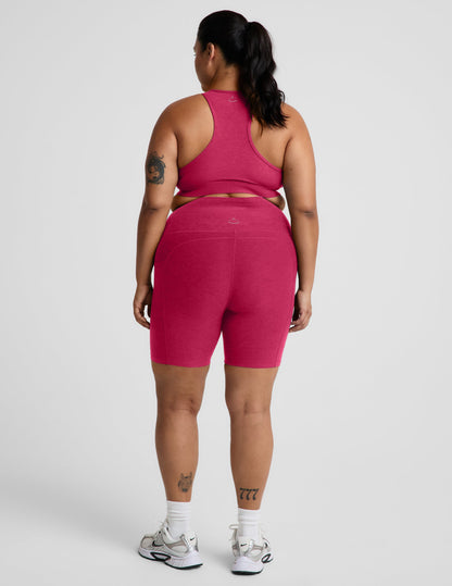 Rear view of woman wearing Pink Spacedye™ Keep Pace 7" Pocket Short paired with a matching racerback bra and sneakers.