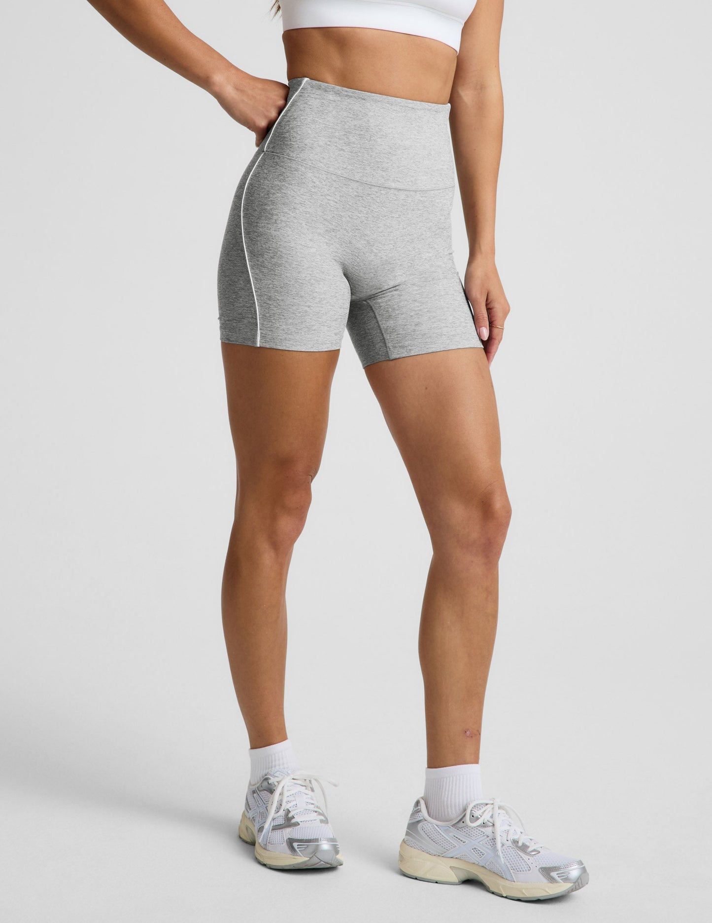 Woman wearing Gray Spacedye™ Streamline 5" Short paired with a white sports bra, featuring a high-rise waistband.