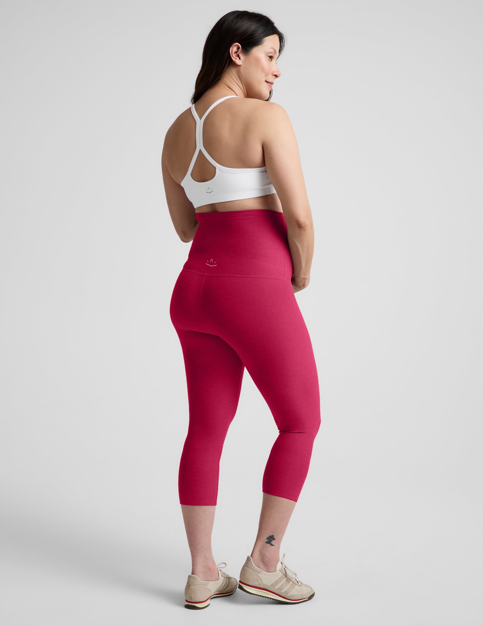 Woman wearing Pink Spacedye™ Love The Bump Maternity 20.5" Capri Legging, rear view, paired with a white sports bra.