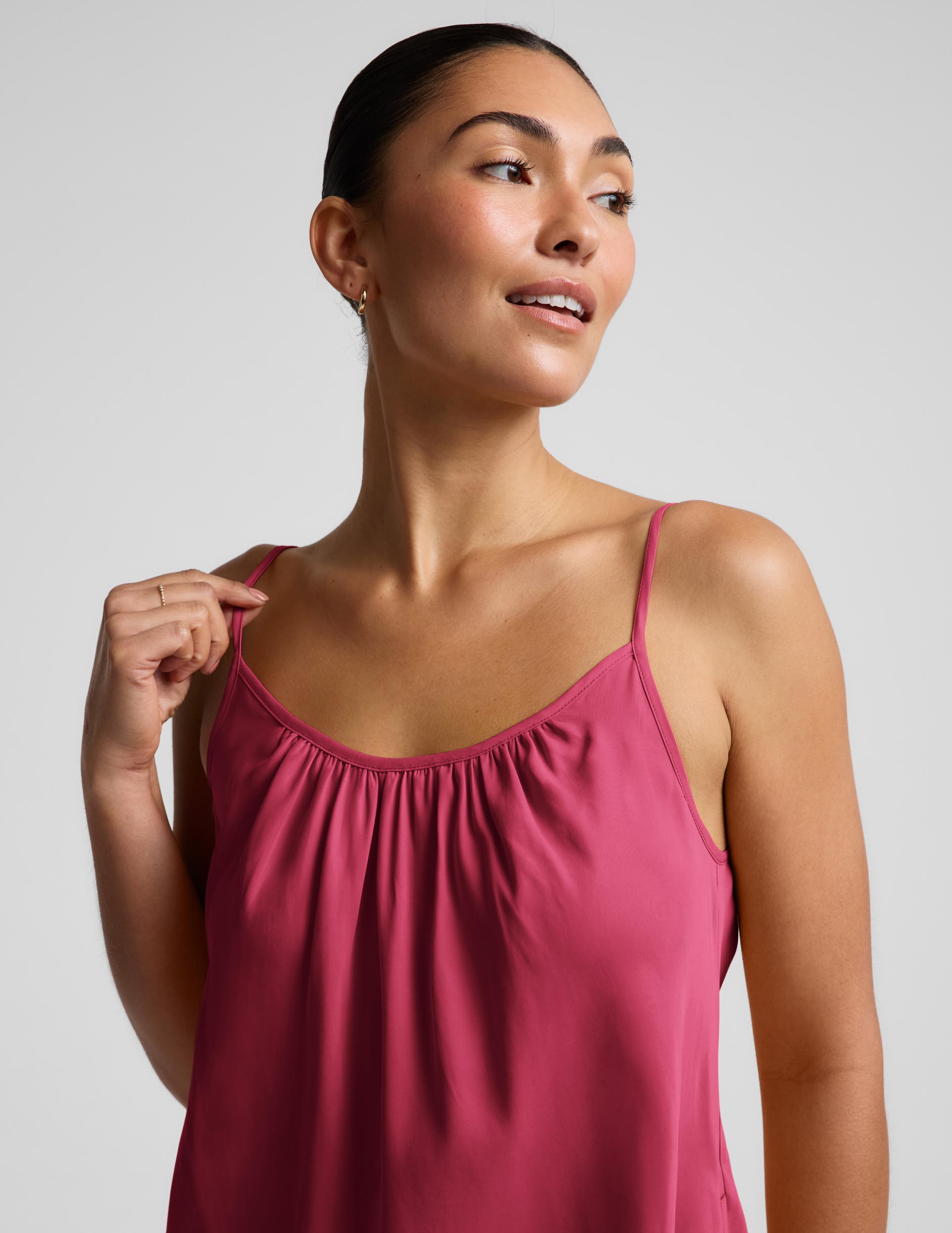 Woman wearing a red mini tank dress against a plain background.