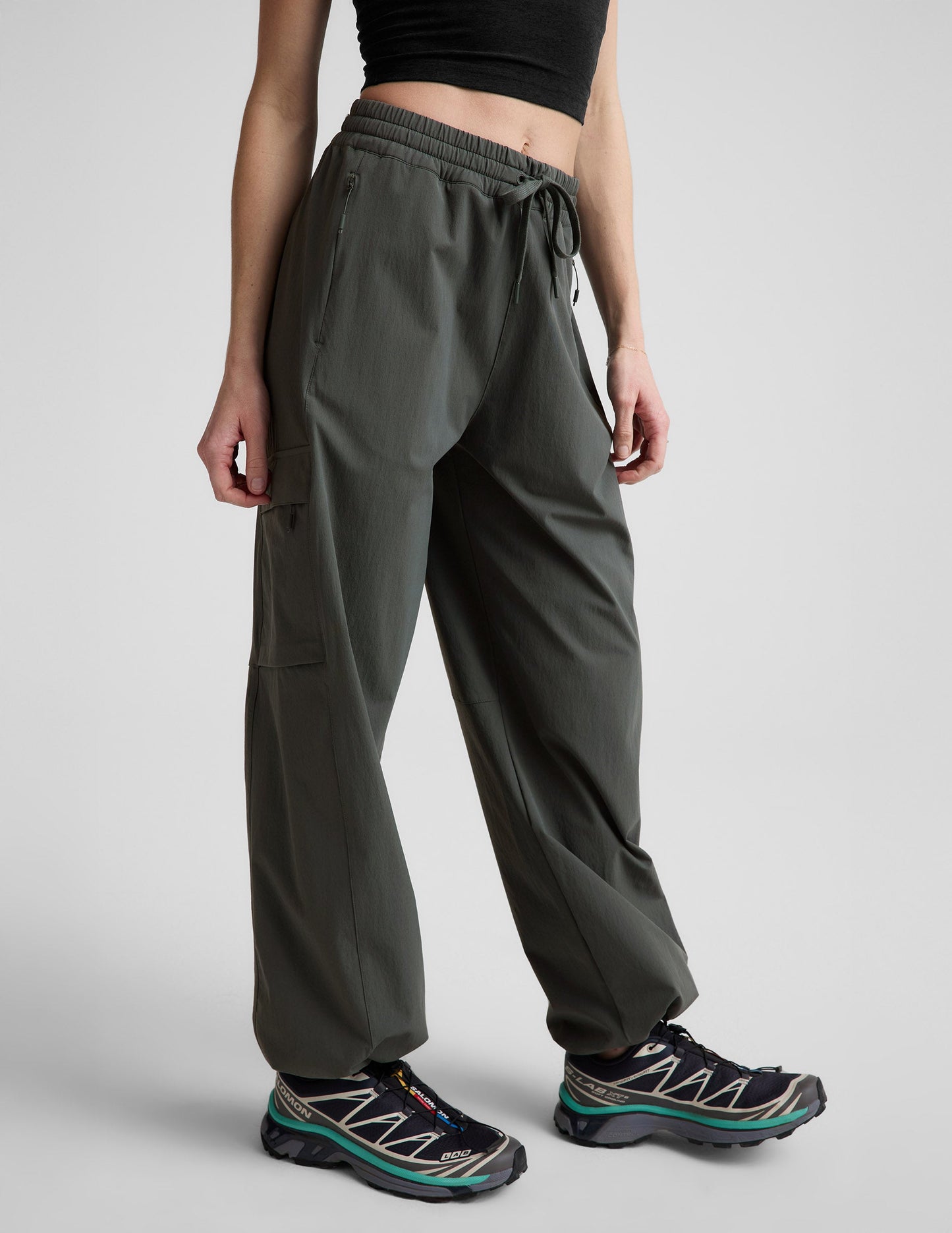 Woman wearing Java Peak Pant™ with a cargo pocket and bungee hem, paired with a black crop top and sneakers.