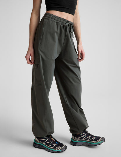 Woman wearing Java Peak Pant™ with a cargo pocket and bungee hem, paired with a black crop top and sneakers.