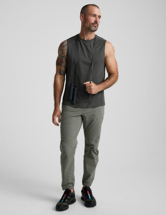 Man wearing olive On The Go Men's Jogger with a relaxed fit and cuffed hems, styled with a gray tank and jump rope.
