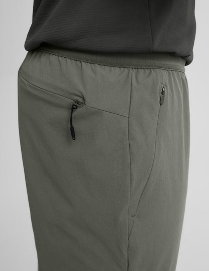 Side view of olive On The Go Men's Jogger highlighting the elastic waistband and discrete side and back zipper pockets.