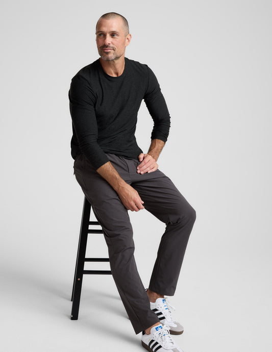 Man sitting on a stool wearing charcoal Men's All Terrain Pant. Straight-leg, regular fit with an elastic waistband.