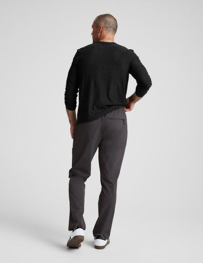 Back view of charcoal Men's All Terrain Pant on a model, showing the relaxed straight fit and zippered back pocket detail.