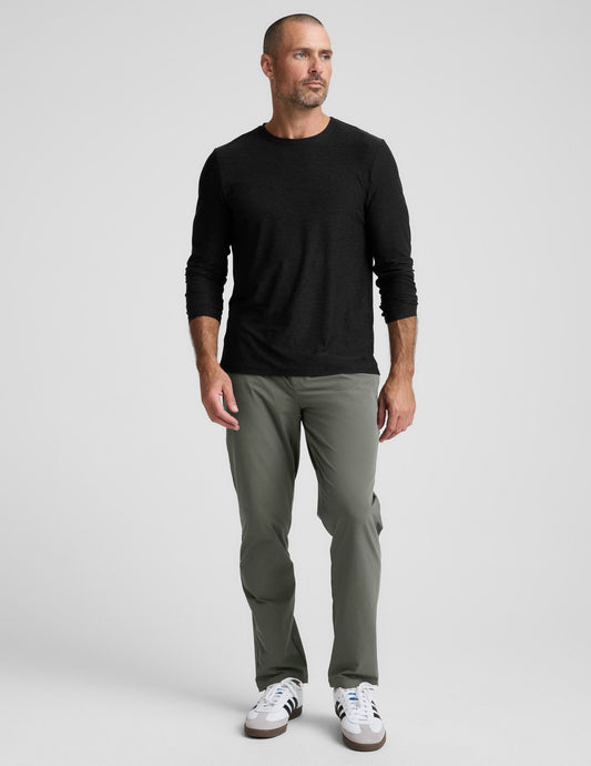 Front view of a man wearing olive green Men's All Terrain Pant with a black long-sleeve shirt and white sneakers.